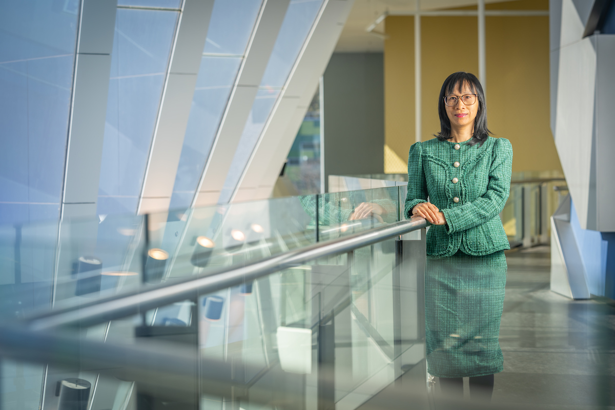 Associate Professor Nhung Nghiem. Photo: Nic Vevers (ANU) Nhung Nghiem is standing next to a balustrade in an office building.