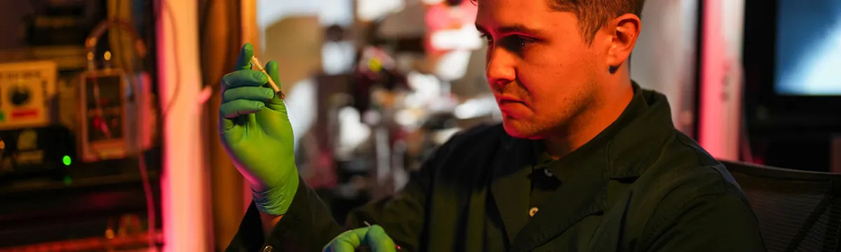 A man looks at a syringe