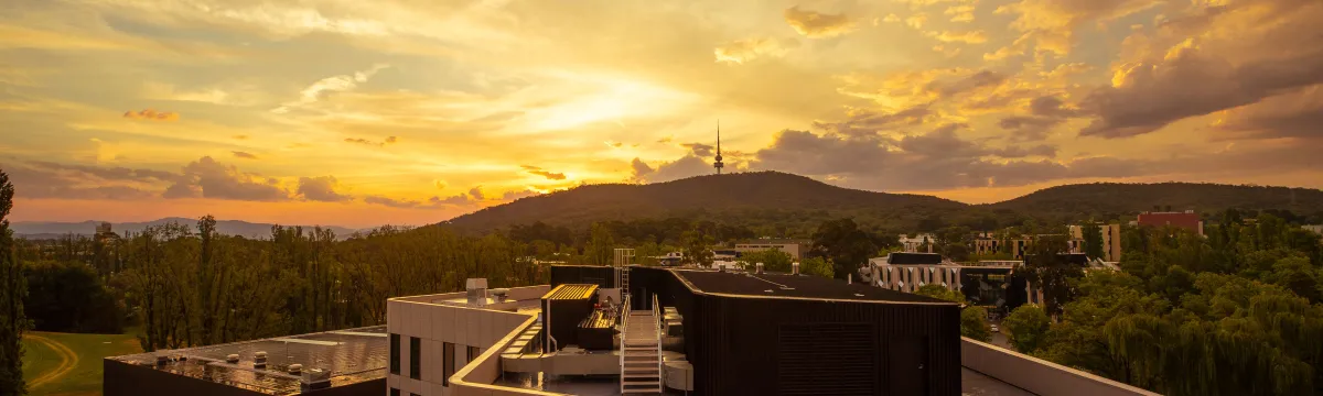 A photo of the sun setting over the ANU campus