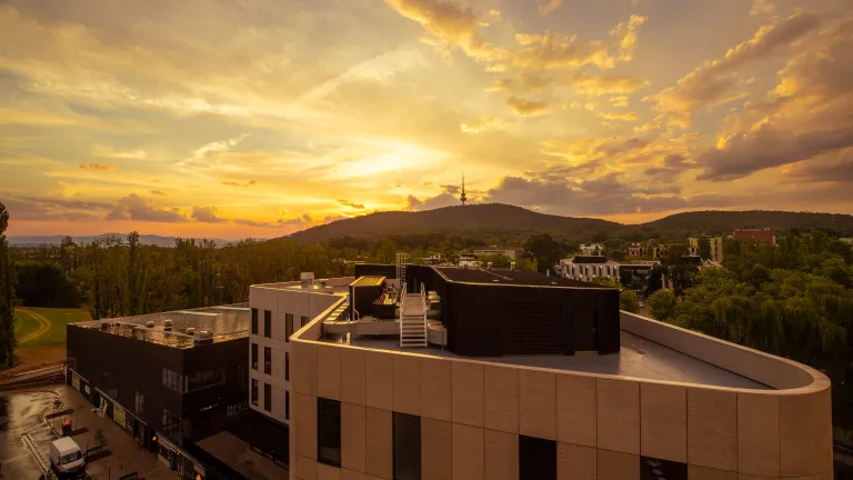 A photo of the sun setting over the ANU campus